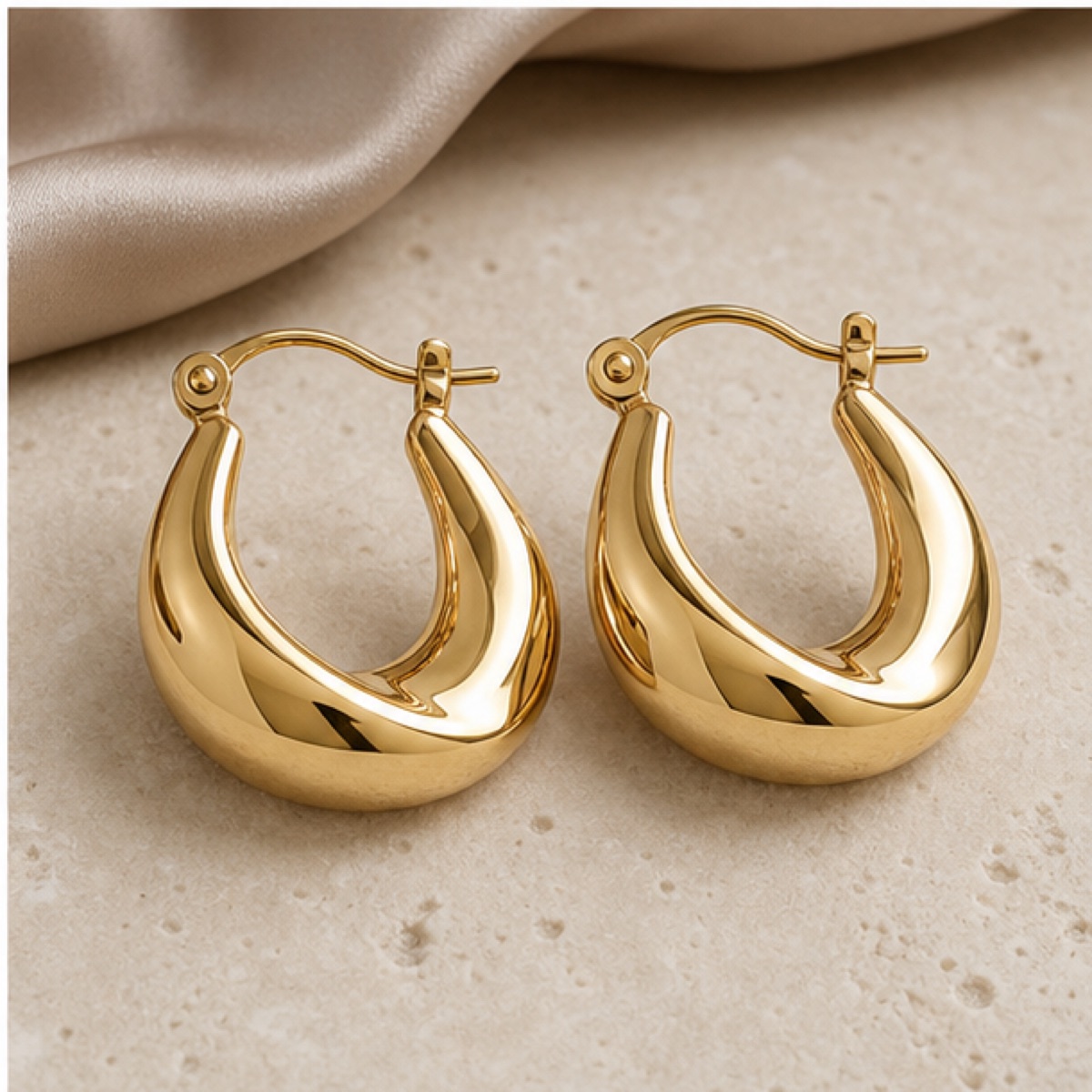 A pair of modern earrings on soft grey silk